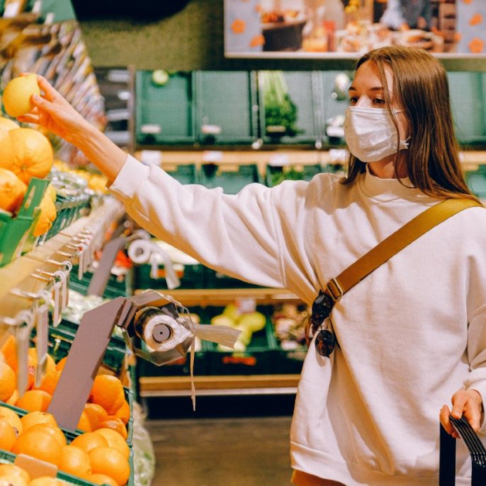 lány leemel a boltban a polcról egy citromot