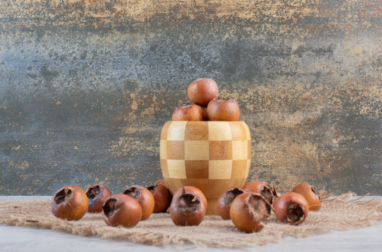 egy tálnyi naspolya, előtte sok apró naspolya