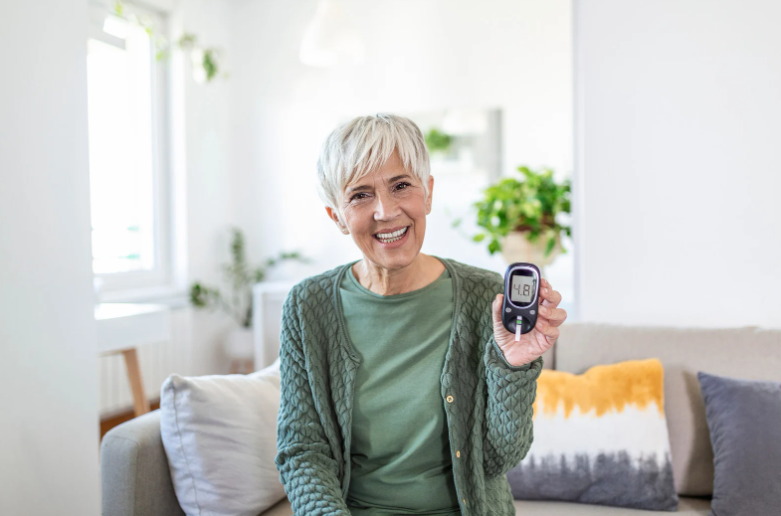 egy idősebb nő vércukorszintmérővel a kezében
