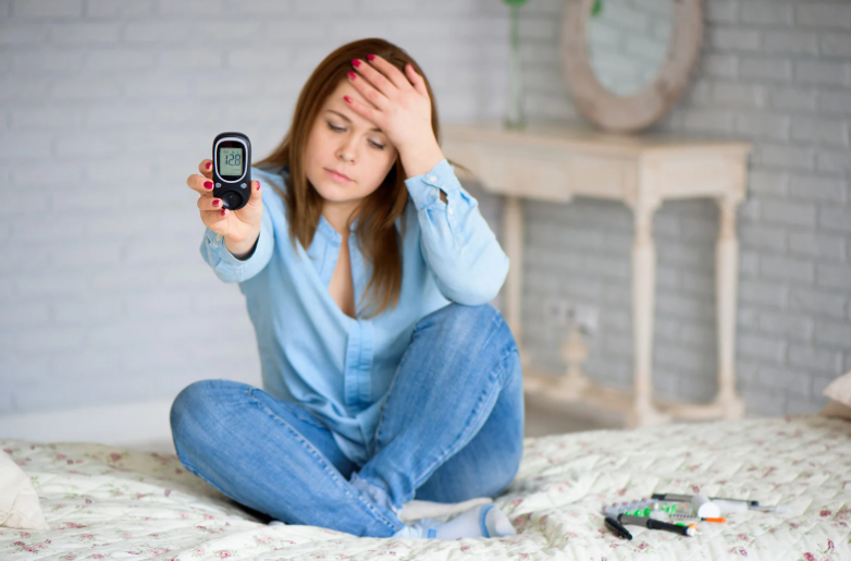 egy nő fogja a fejét a magas vércukorszint miatt