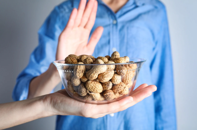egy tál héjas földimogyrót tart egy kéz, a másik felemelve elutasítja