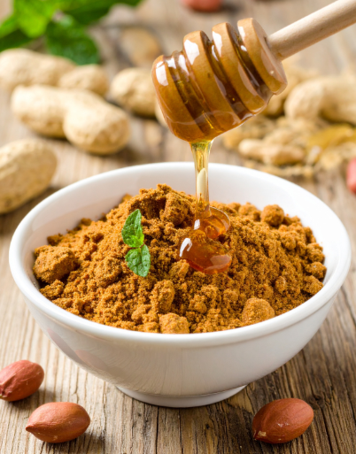 egy tál mogyoróvajporra csorgatva egy kis méz