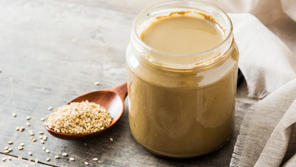 tahini és szezámmag üvegben fa asztalon